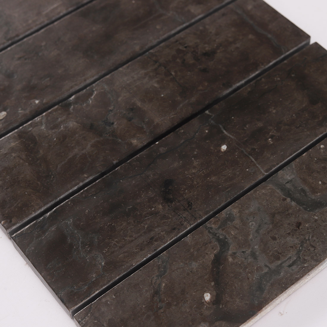 High angle view of dark brown linear marble mosaic tiles in parallel