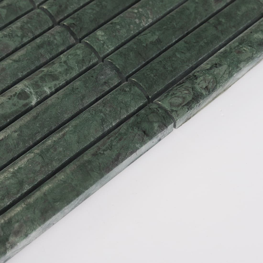Angled edge view of dark green marble finger mosaic tile