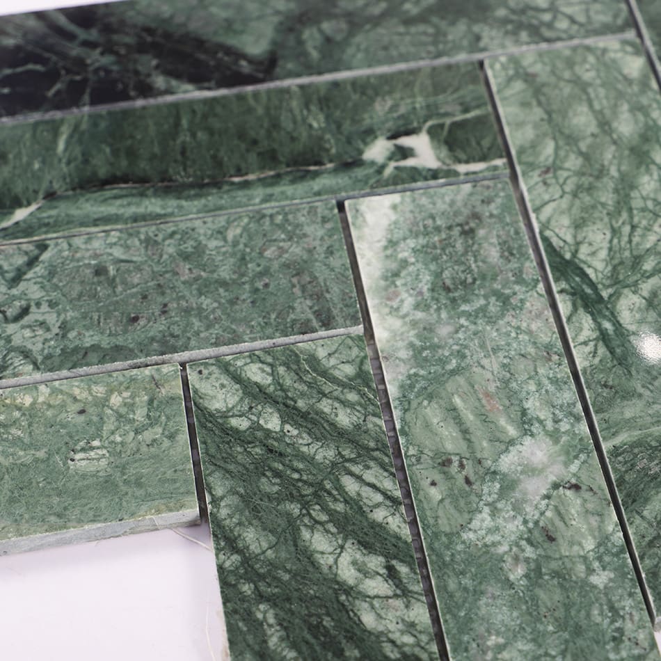 Close-up of dark green marble herringbone mosaic tile pattern