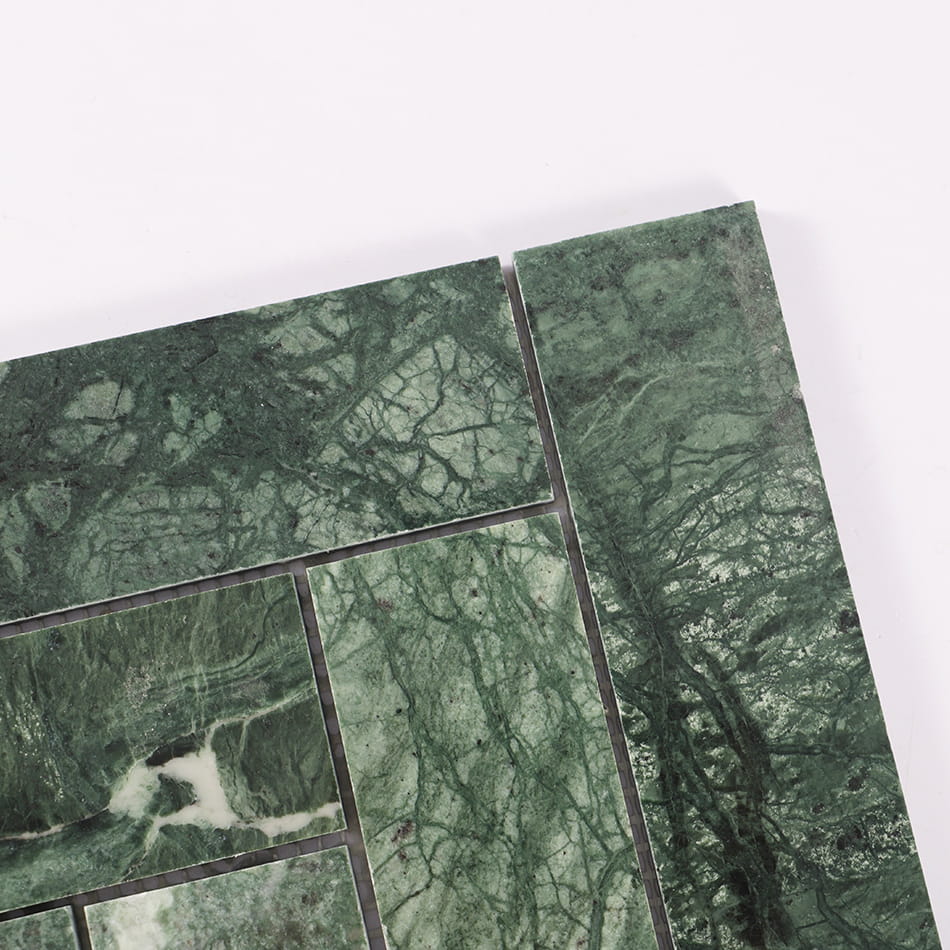 Corner detail of dark green marbl herringbone mosaic tile