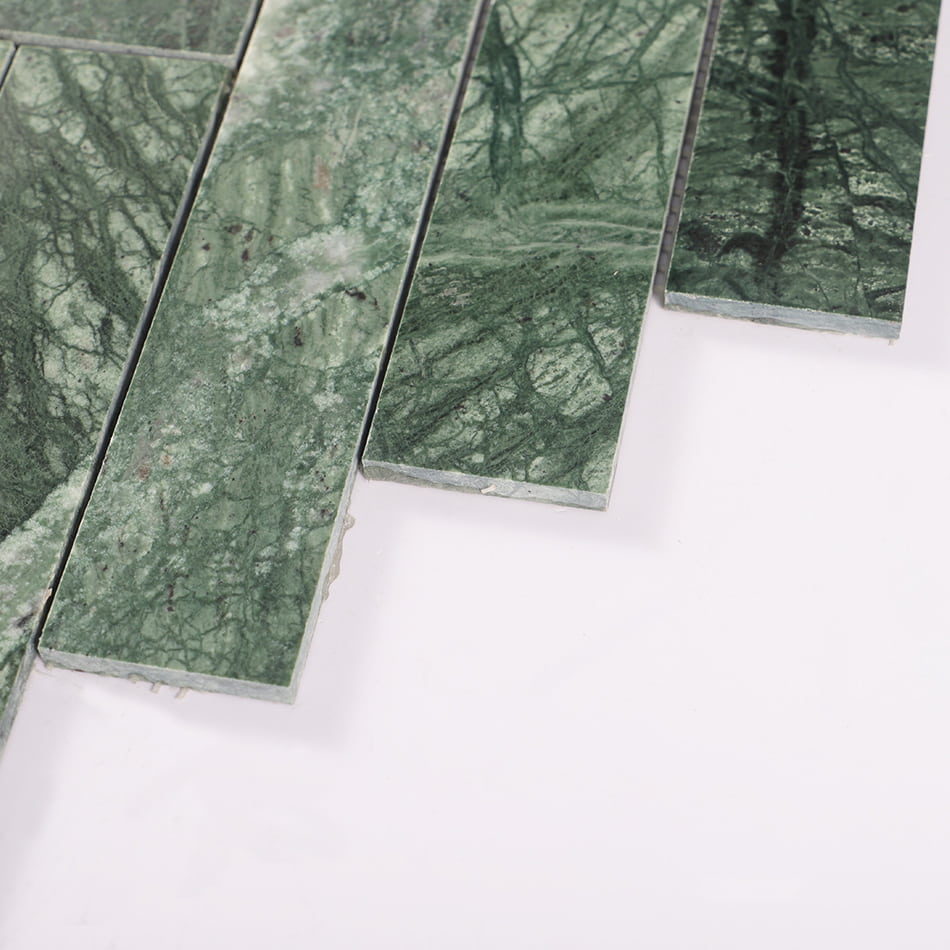 Edge detail of dark green marble herringbone mosaic tile