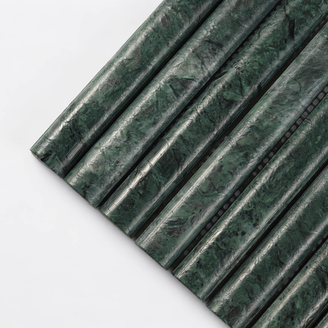 Close up of dark green marble rounded baton mosaic tile with natural veins