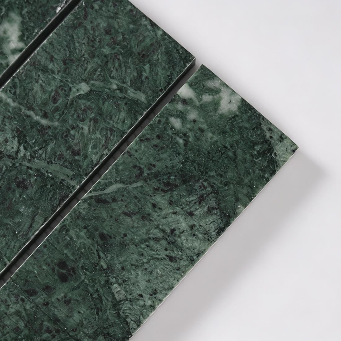 Close-up texture of dark green marble strip tile with natural veining