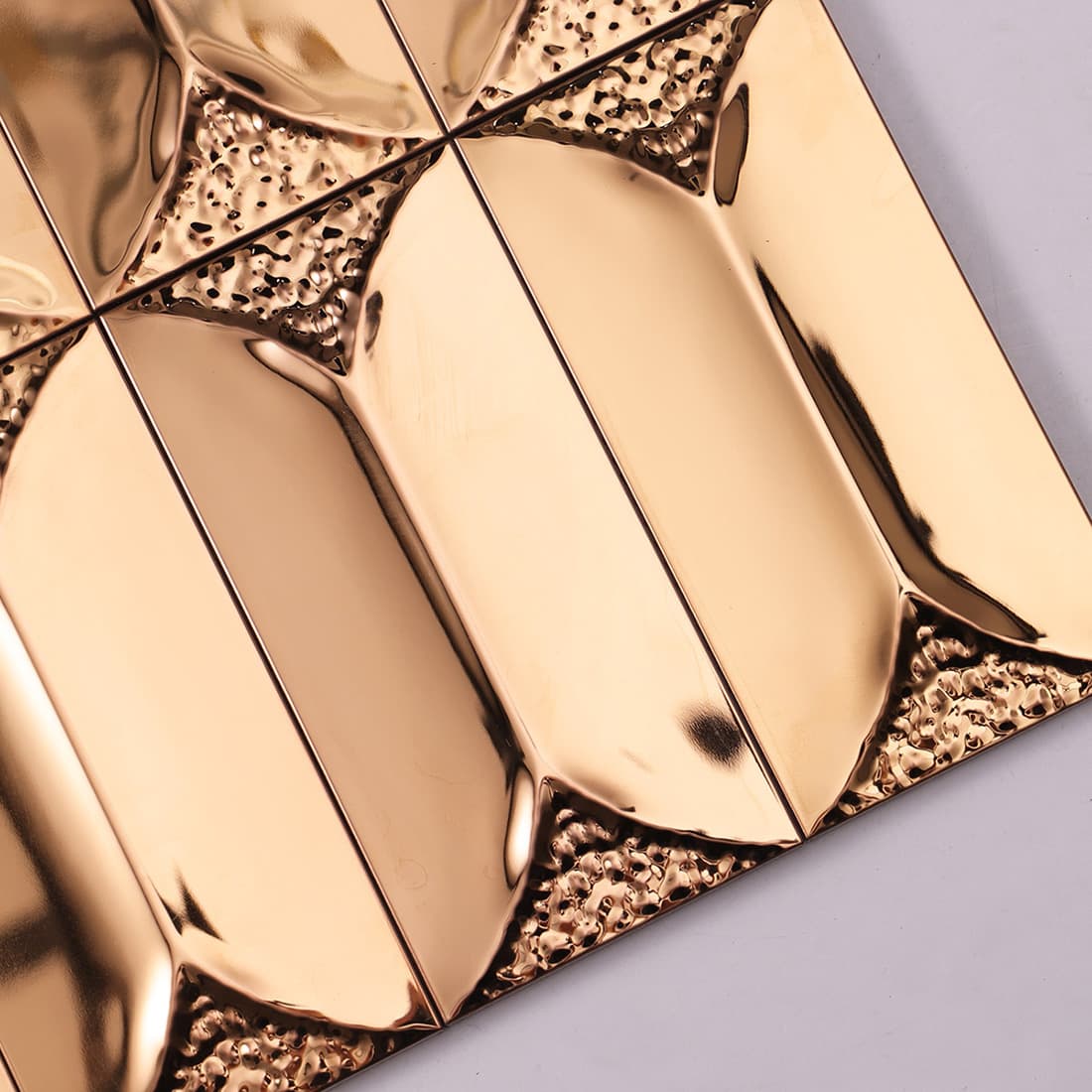 Detailed macro shot of rose gold 3D metal tiles with hammered textured accents.
