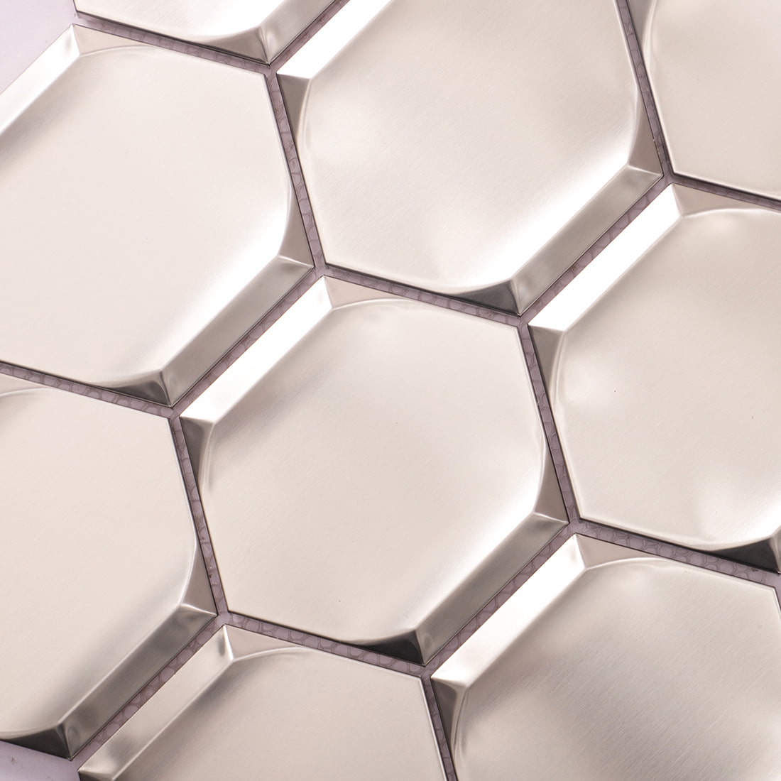 Detailed view of silver brushed beveled hexagon stainless steel tile pattern