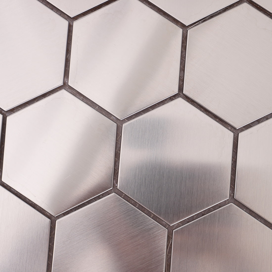 Detailed view of the gaps and brushed metallic finish of several interlocking hexagon tiles.