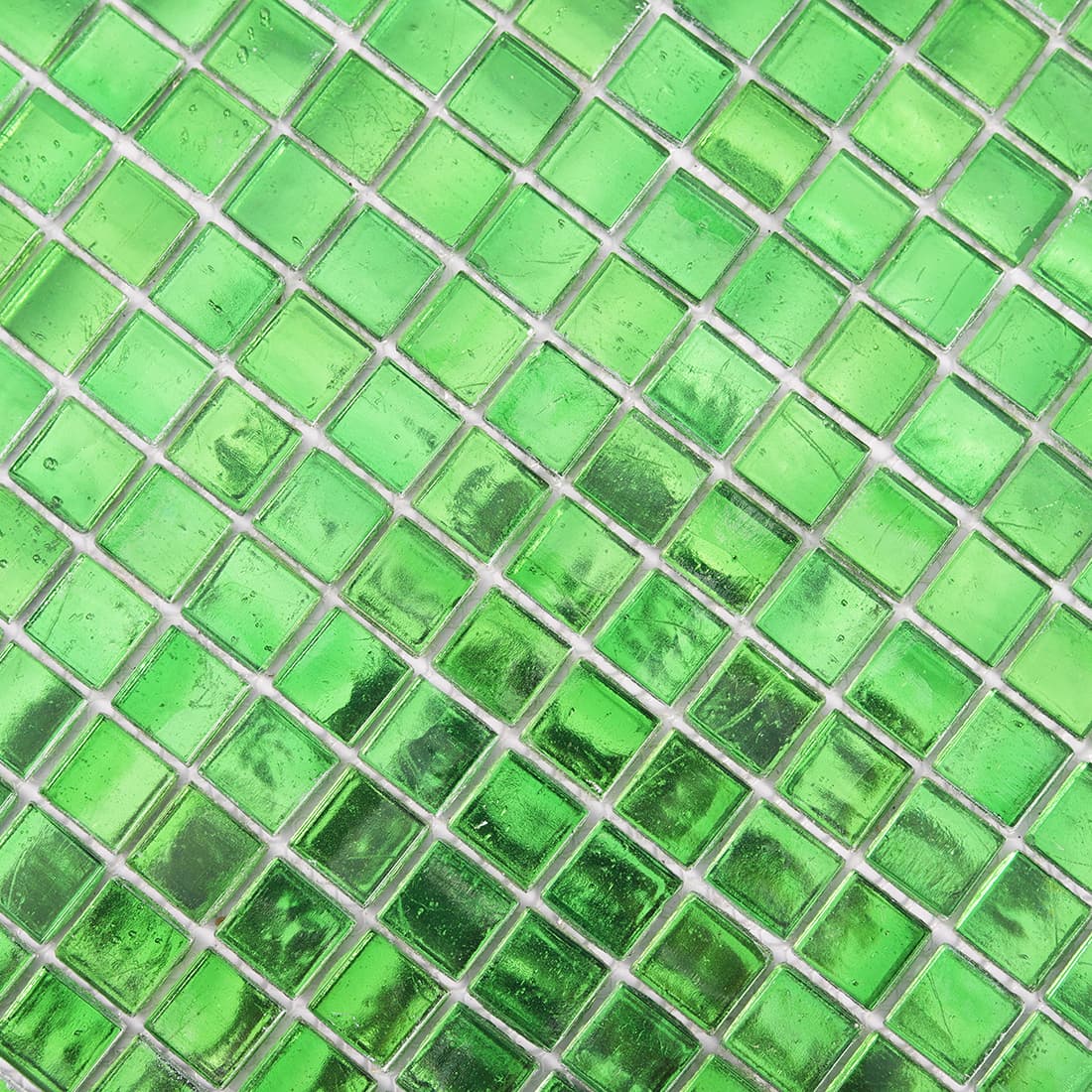 Macro close-up of bright green glass mosaic tiles showing subtle foil texture and color 