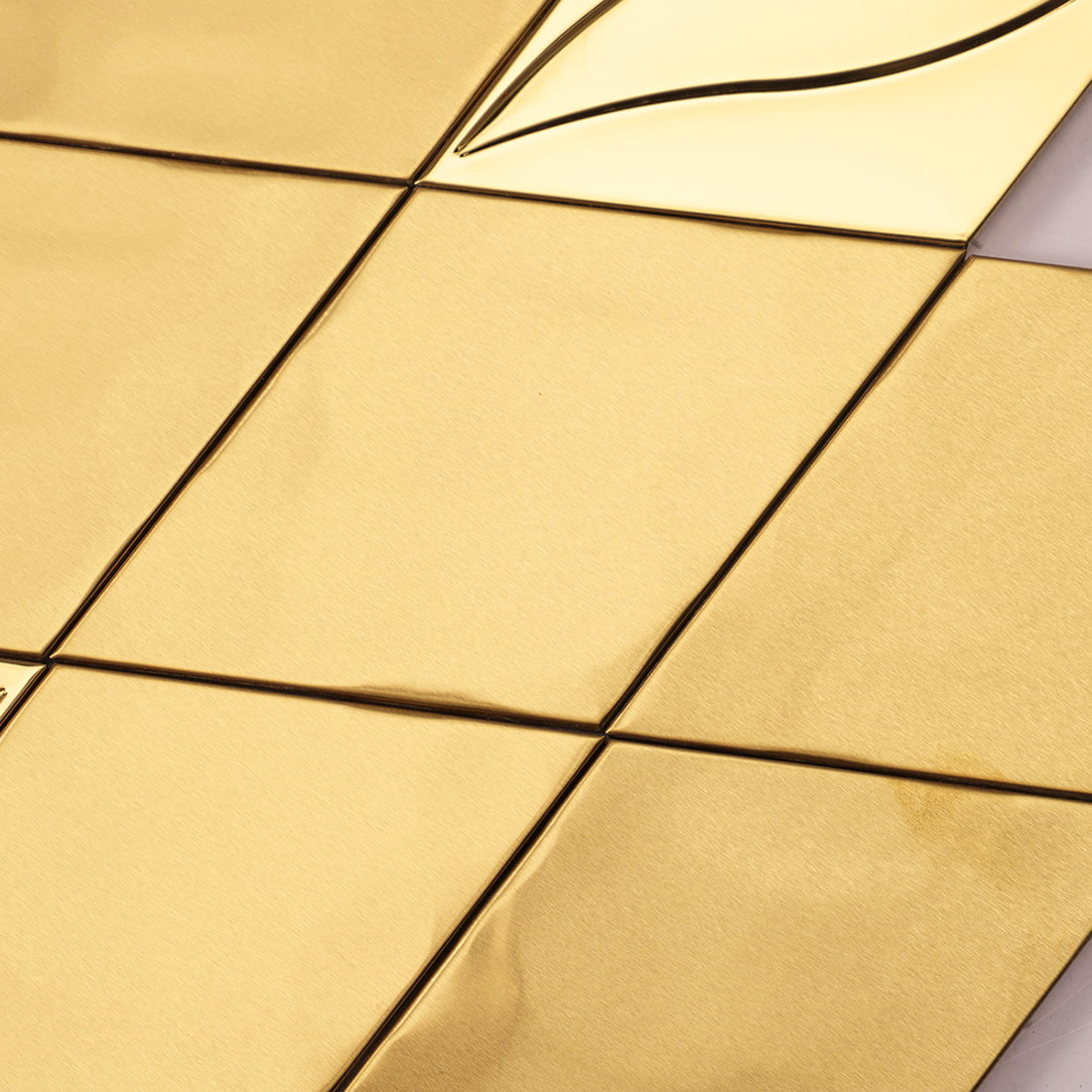 Close-up view of flat brushed gold diamond mosaic wall tiles.
