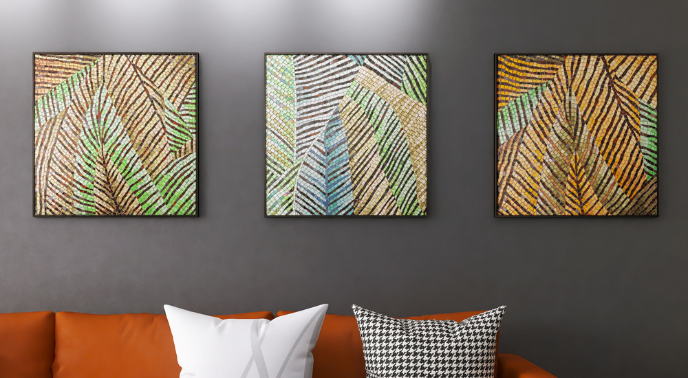 {"default":"Three framed abstract leaf-pattern mosaic artworks on a gray wall above a sofa"}
