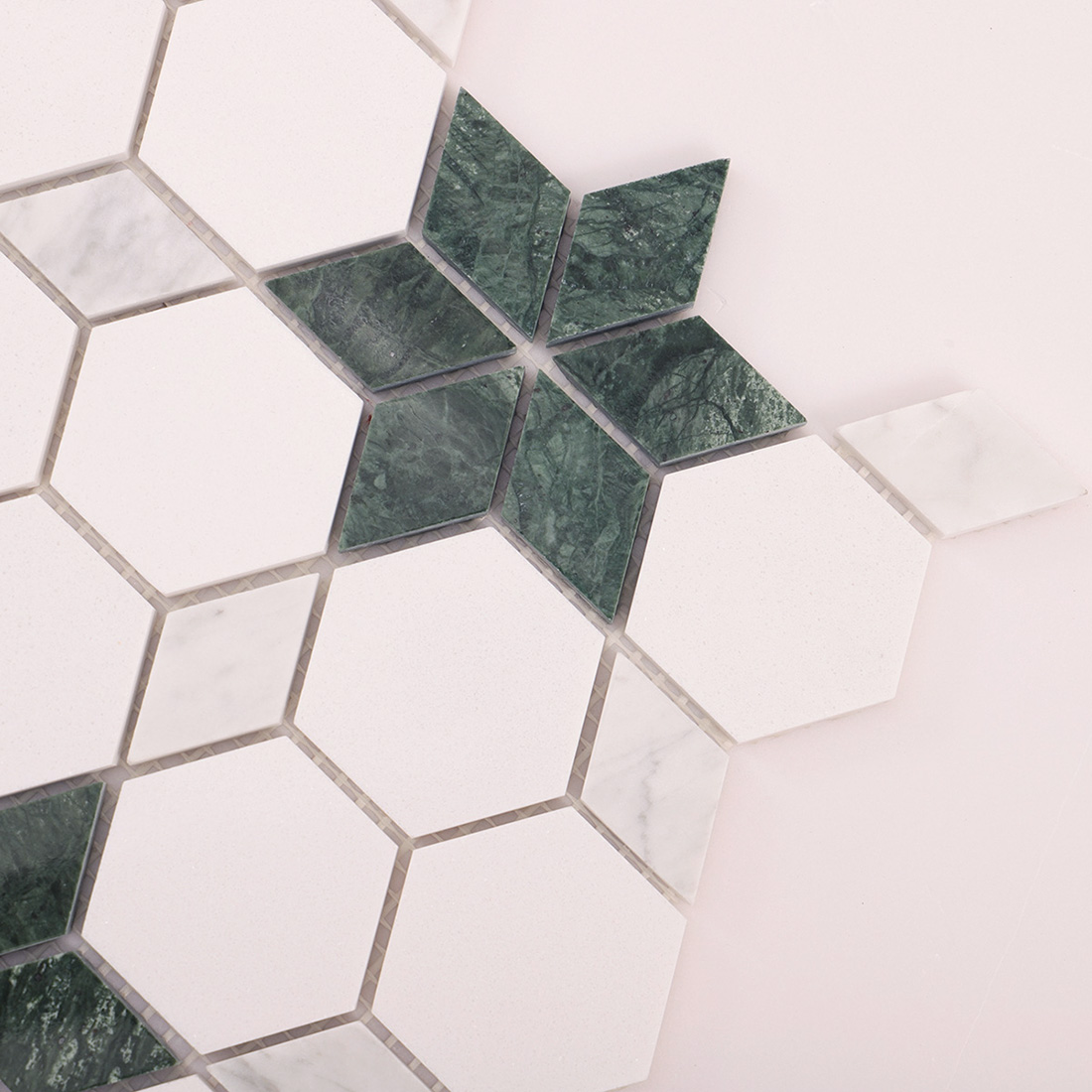 White hexagon and green star marble mosaic tile on a light background.