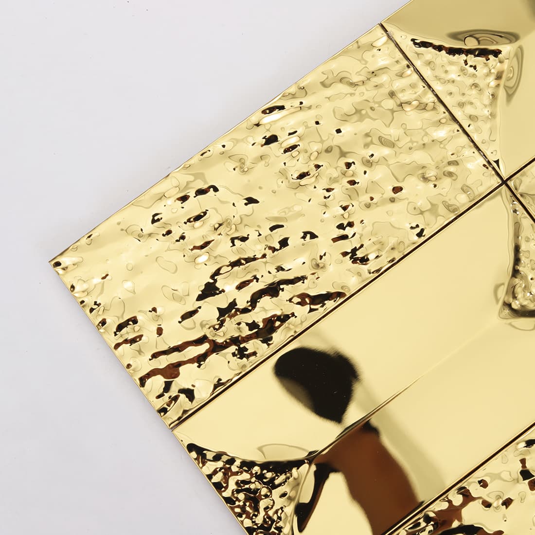 Close up of gold hammered rectangular metal mosaic with glossy finish