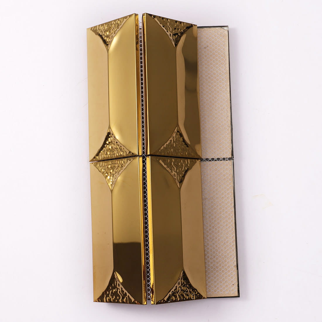 Display of gold metal mosaic tiles showing the fiber mesh backing.