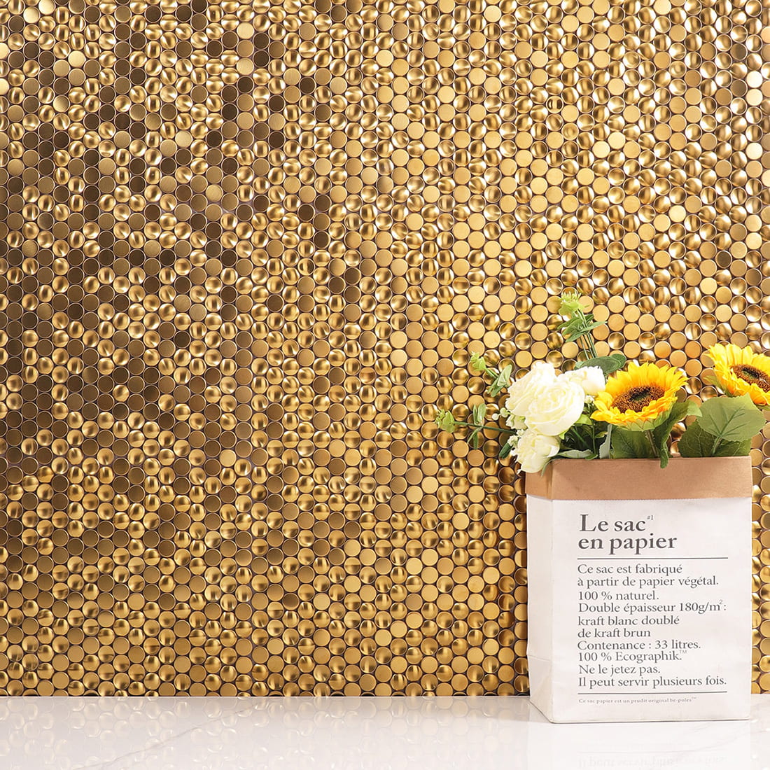 Gold metal mosaic tile wall installation with flower decor.