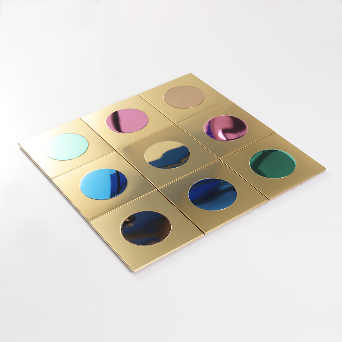 Perspective view of gold metal square tiles with multicolor round mirror inserts