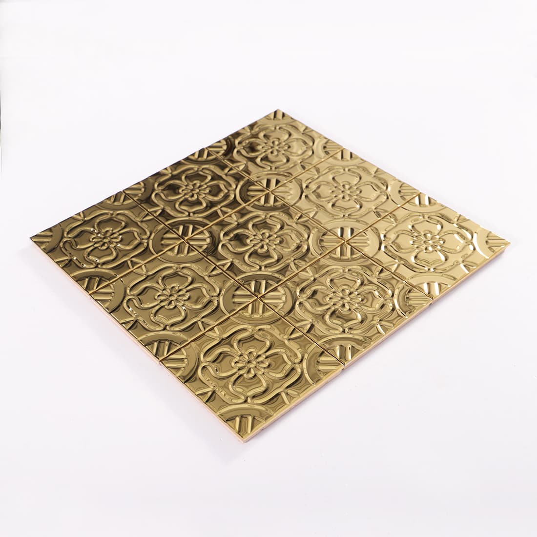 Angled view of gold stainless steel embossed floral mosaic sheet