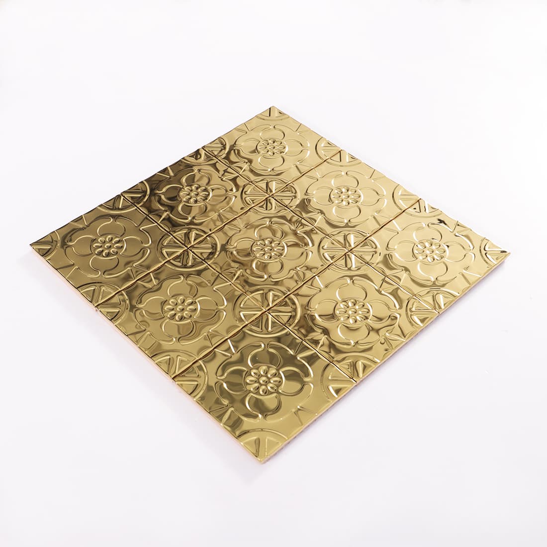 Angled view of gold stainless steel floral embossed square tile sheet
