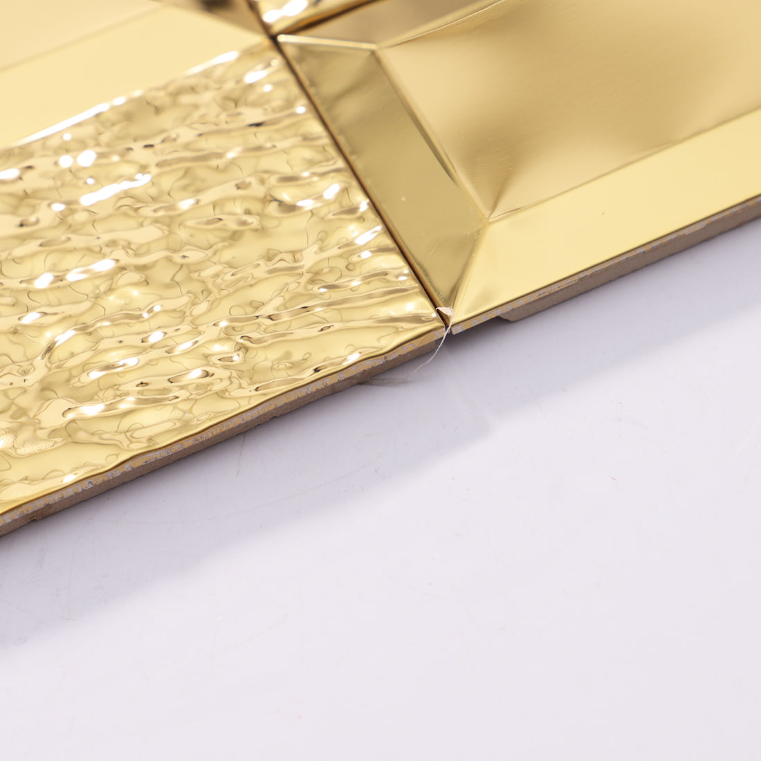 Edge detail of gold textured rectangular metal mosaic tile sheet