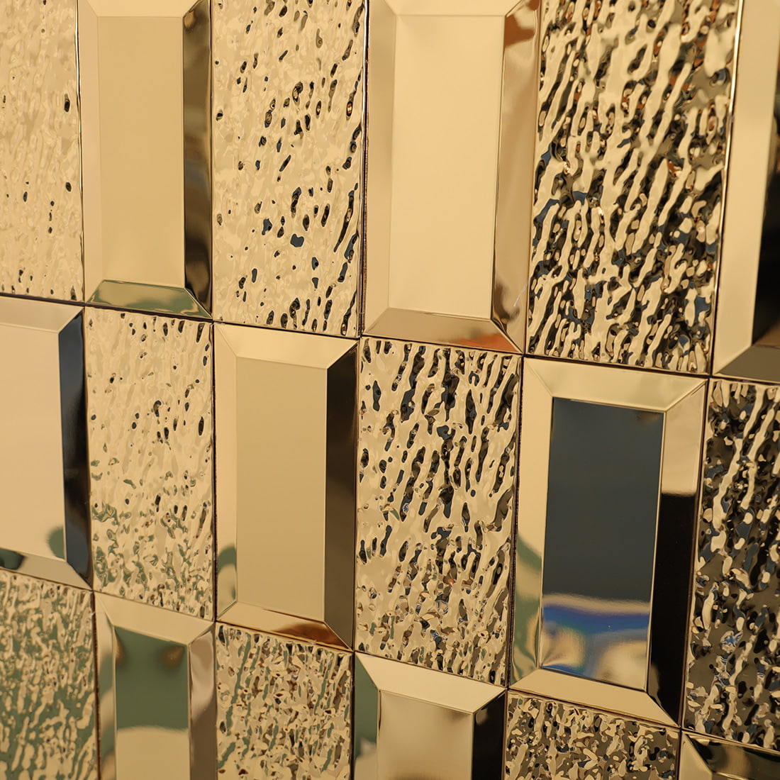 Close-up wall view of gold textured rectangular metal mosaic tiles