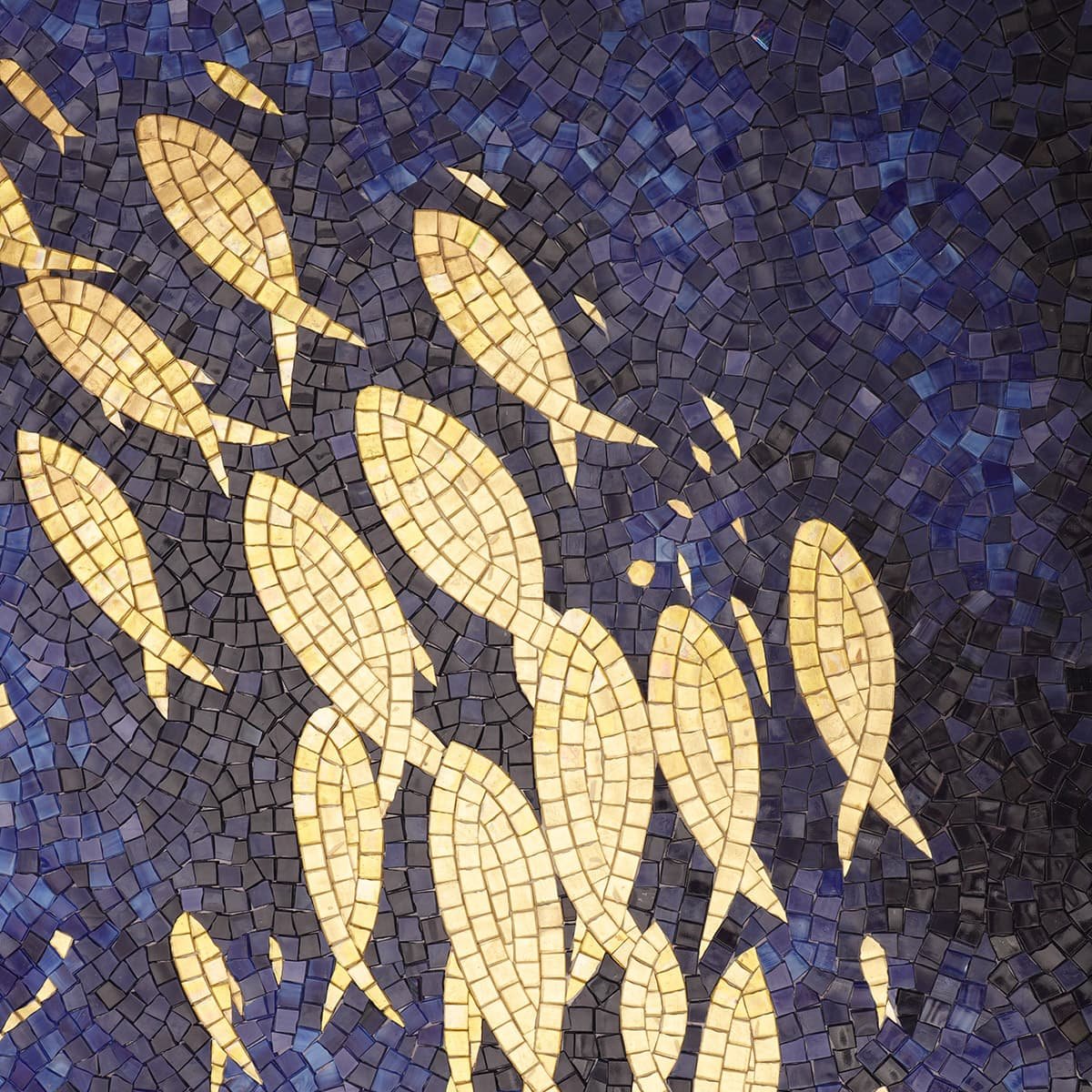 Golden fish mosaic art close-up with deep blue background.