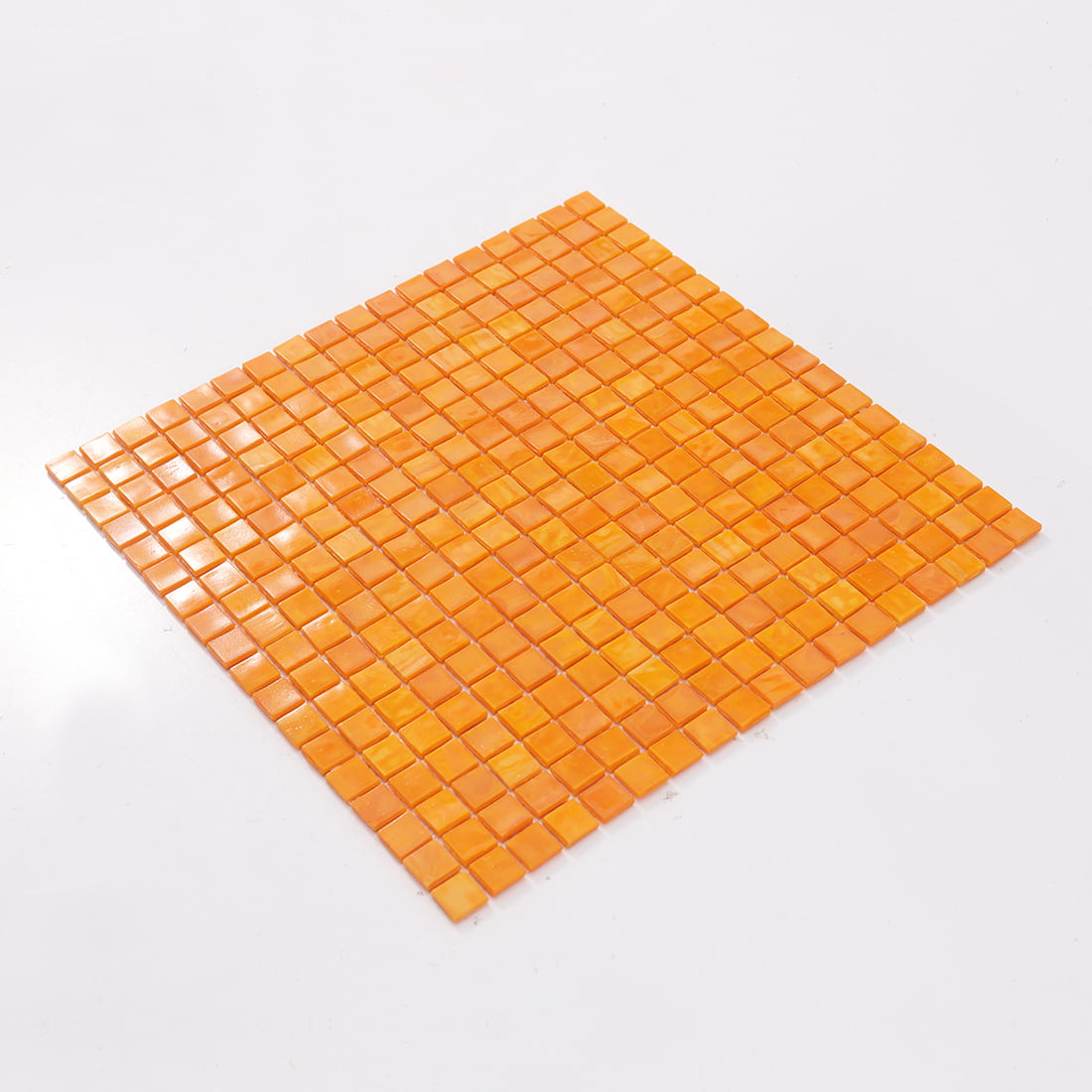 Angled view of golden orange square glass mosaic tile sheet
