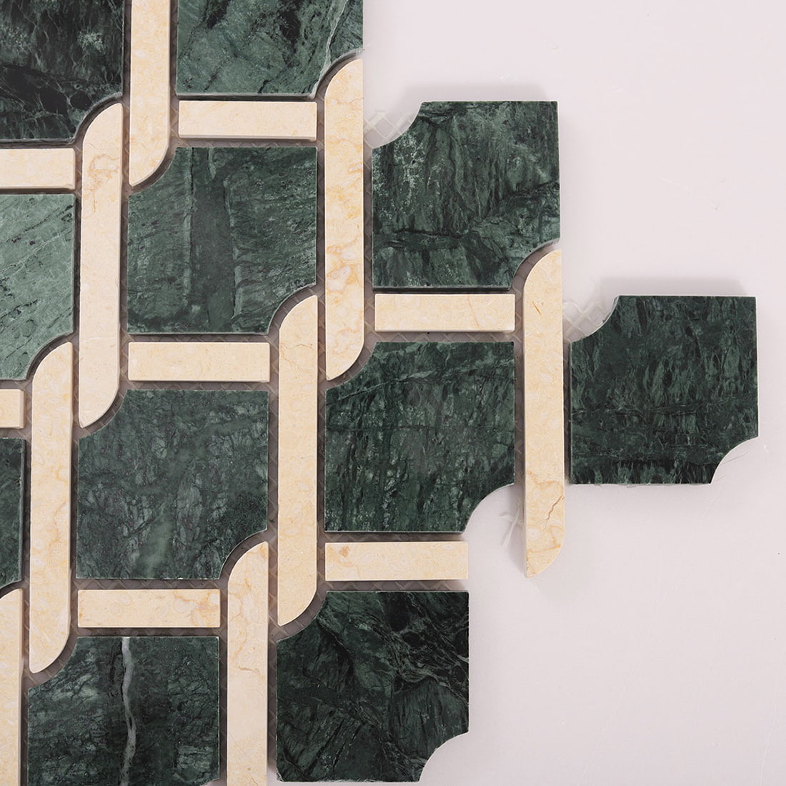 Edge detail of green and beige marble chain link mosaic tile