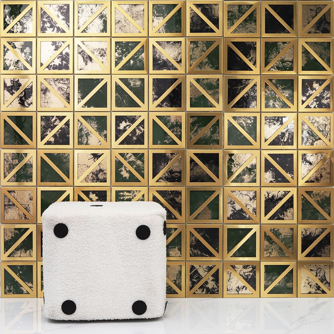 Gold framed square mosaic wall in green black tones with white stool scene