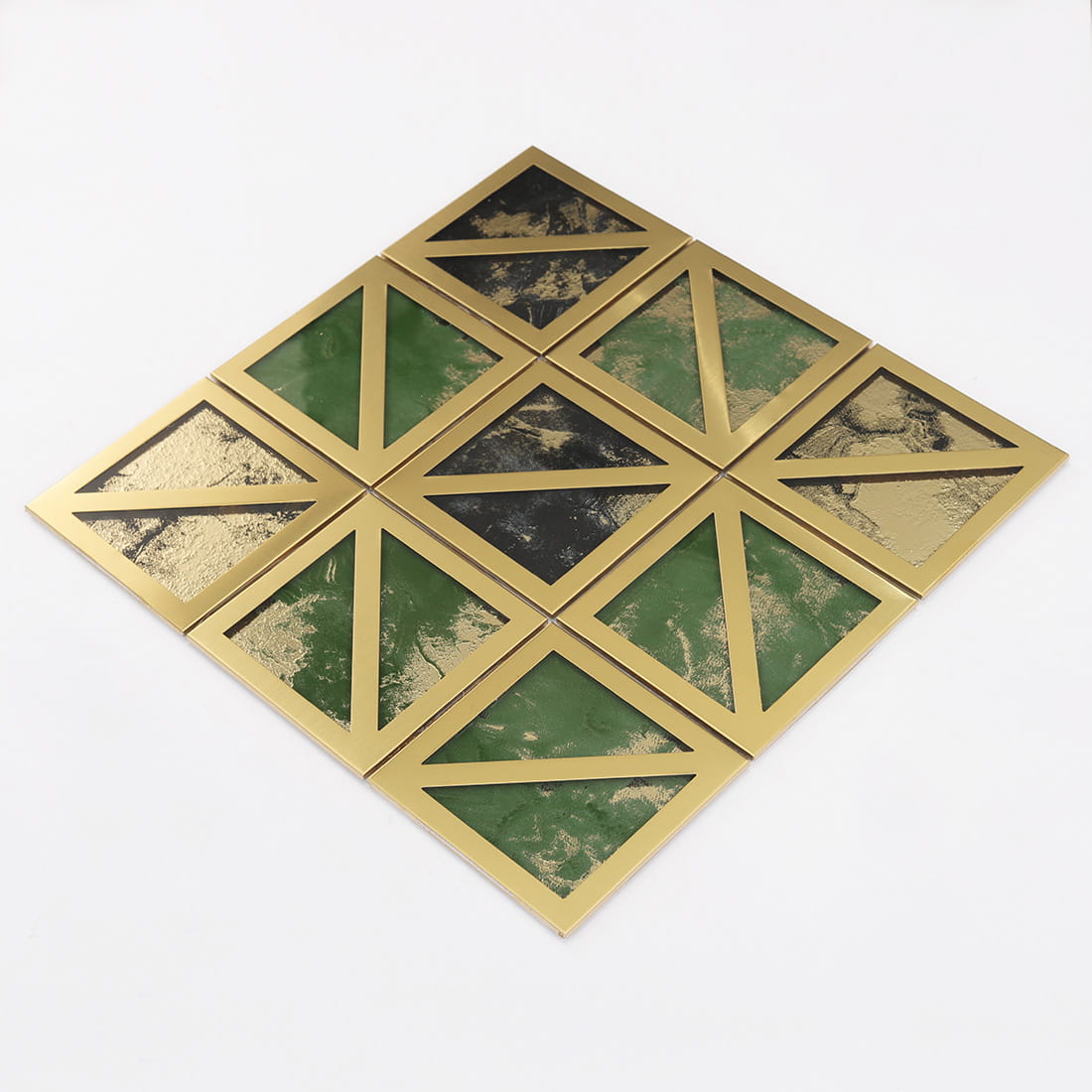 Angled view of gold framed square mosaic tile with green and black glass