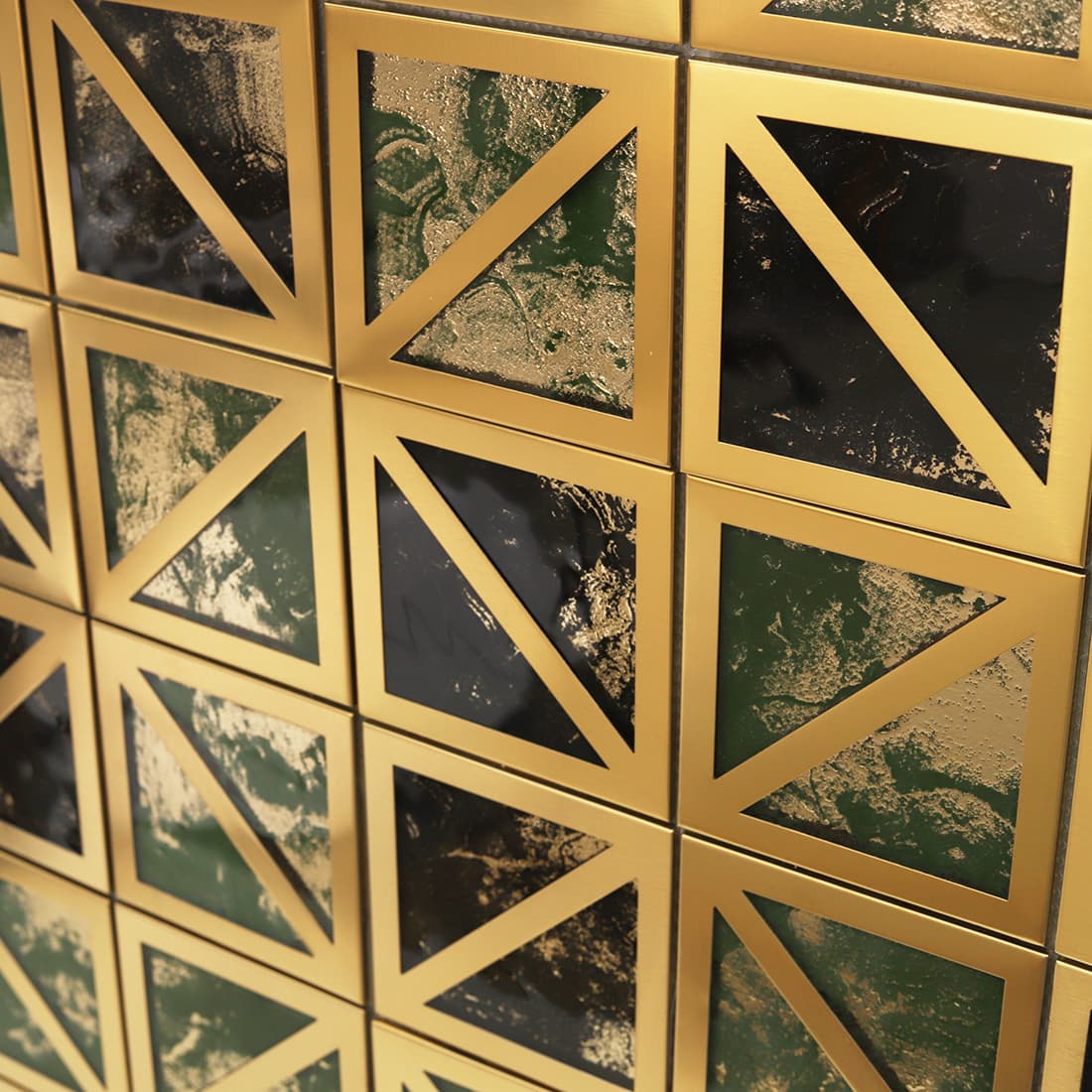 Close up wall display of gold framed square mosaic with green and black glass