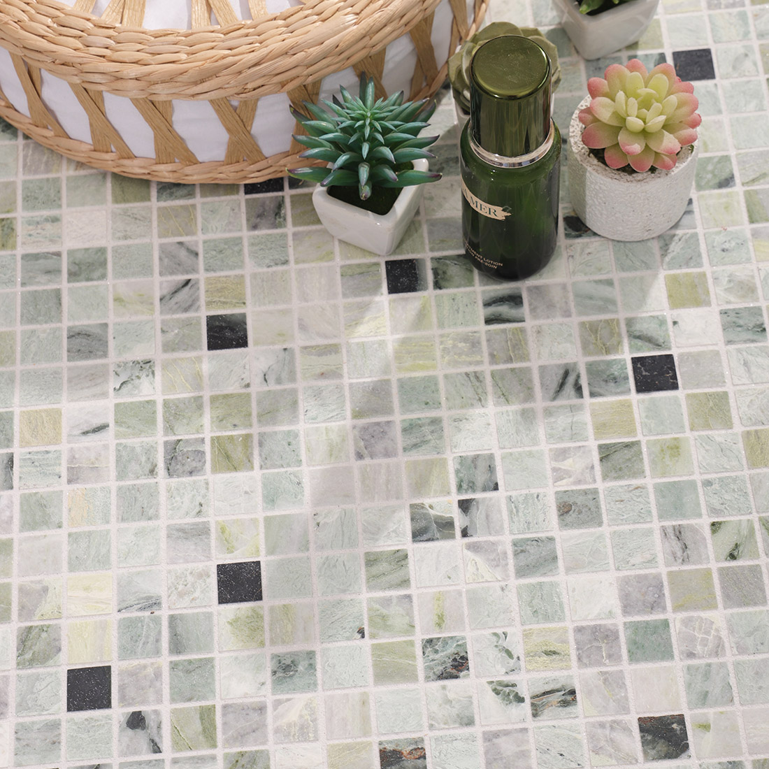 Green marble mosaic tile vanity surface styling with plants and accessories.