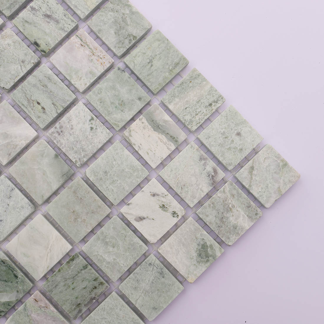 Green marble square mosaic tiles arranged diagonally on light lavender background.