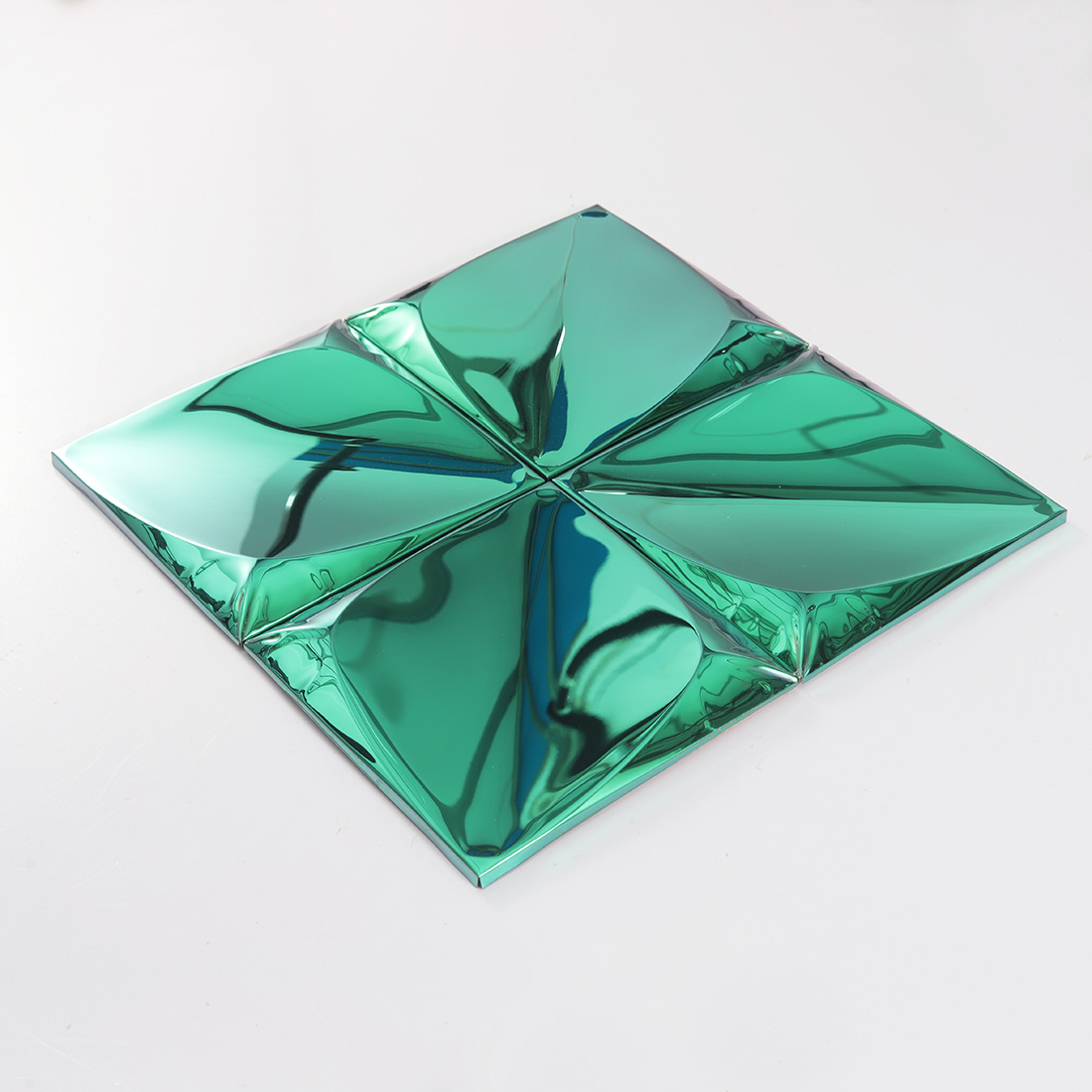 Perspective view of green raised metal tiles with glossy 3D geometric surface