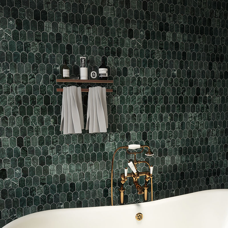 Green scallop marble mosaic tile wall behind a white bathtub