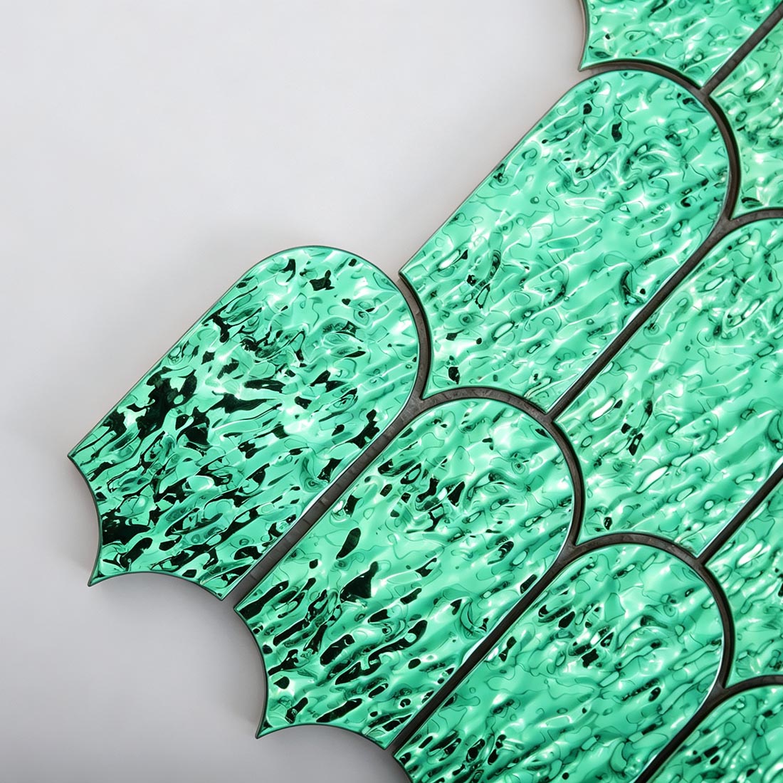 Detailed view of green scallop metal mosaic tile layout and surface detail