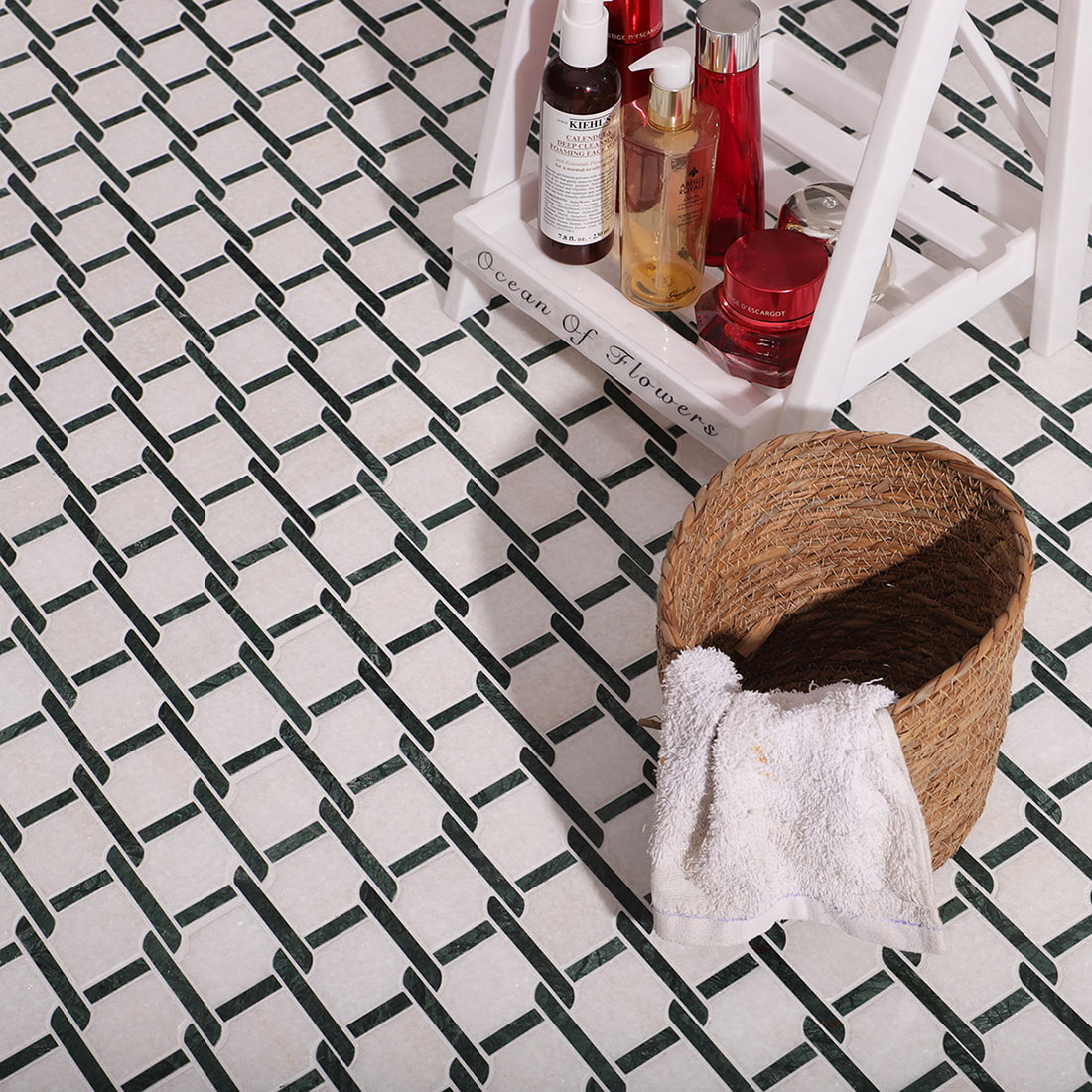 Green and white marble mosaic tile used on bathroom floor with decor items