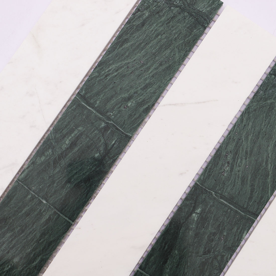 Close-up green and white marble strip mosaic tile with natural veining.