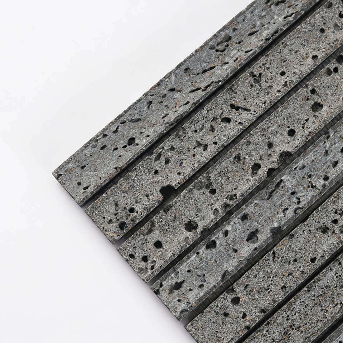 Corner detail of grey porous lava stone linear mosaic.