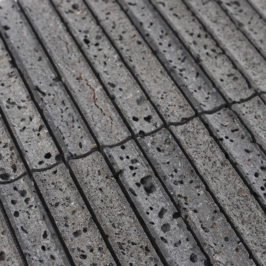 Detailed porous texture of grey lava stone linear mosaic.