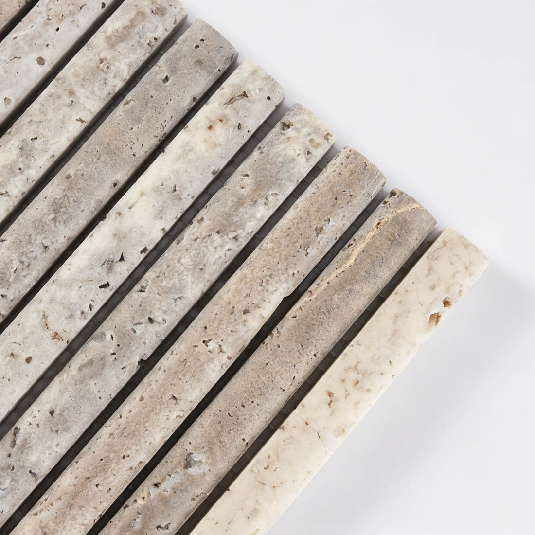 Close-up of curved semi-circle profile on grey travertine rod tile.
