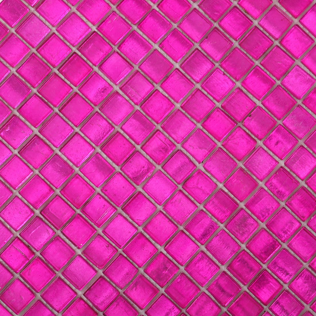 Close-up of hot pink foil-backed square glass mosaic surface