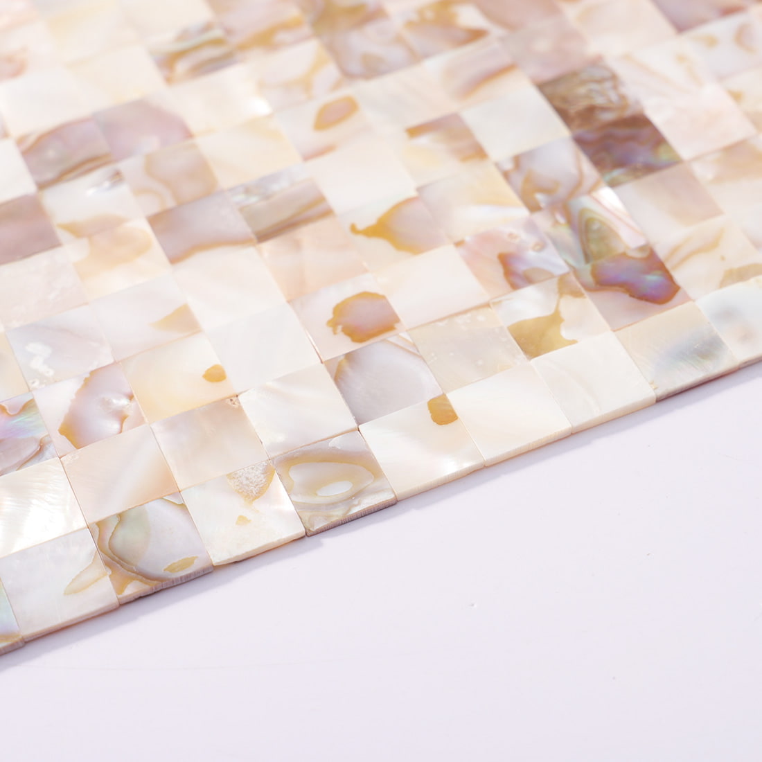 Close up of iridescent shell square mosaic tile sheet edge detail