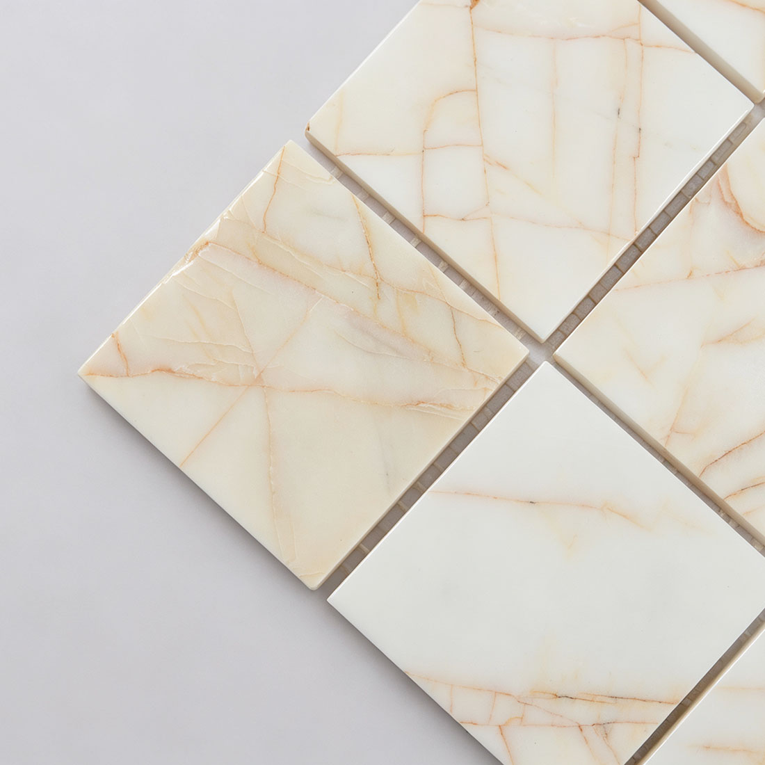 Edge detail of ivory square stone tiles with natural amber veins
