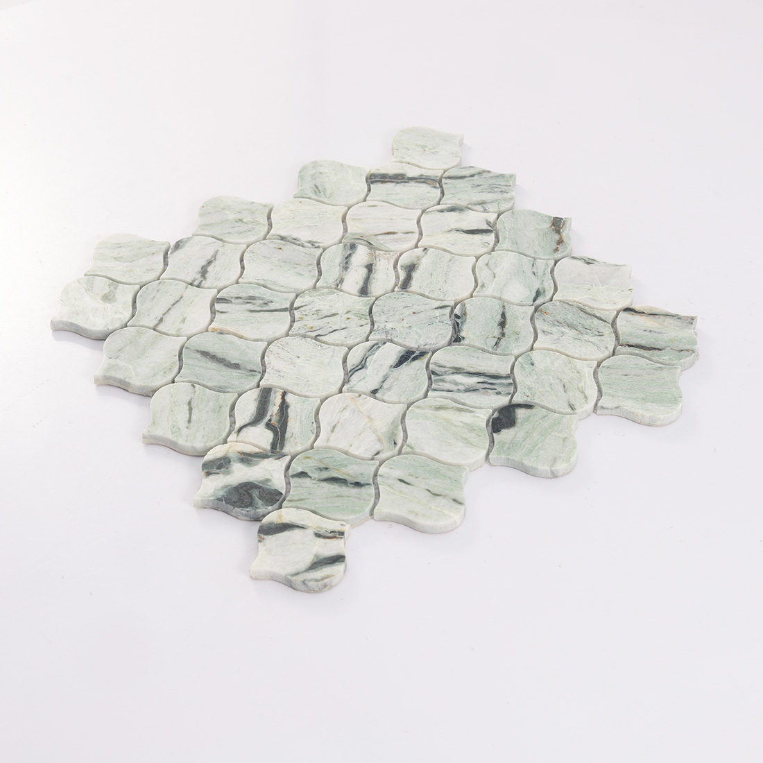 Angled detail of light green lantern marble mosaic tile with curved edges