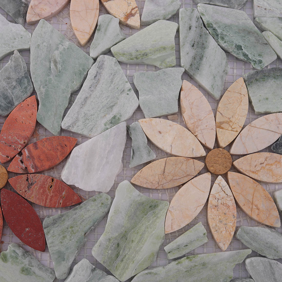 Close-up of light green stone pieces and floral marble mosaic