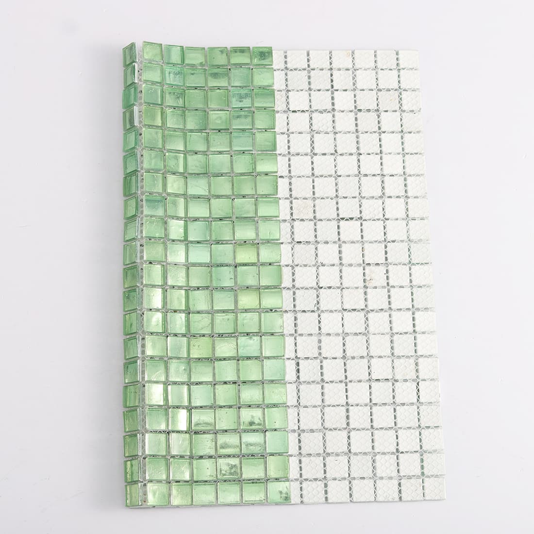 Back view of light green square glass mosaic tile with mesh backing
