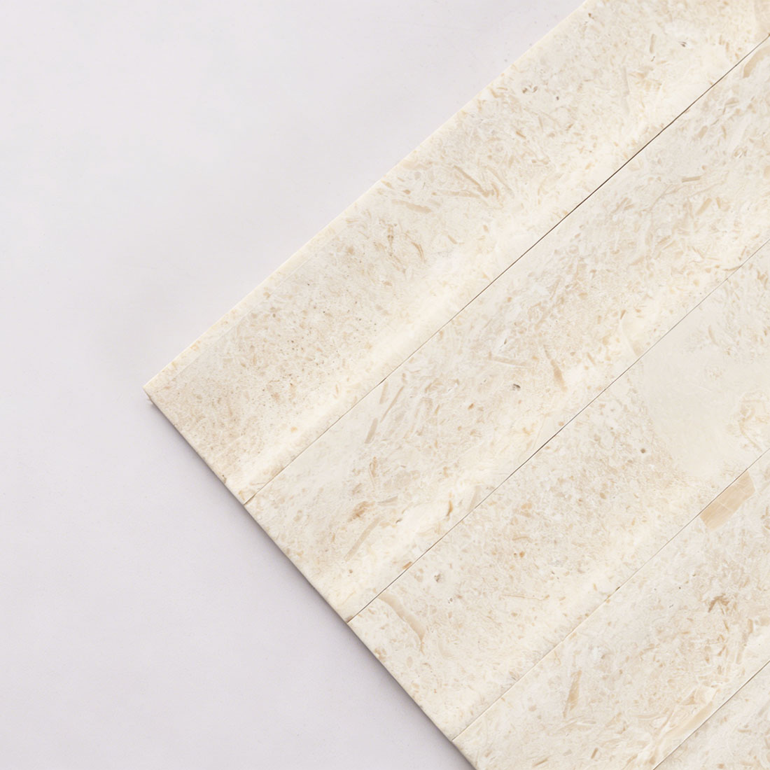 Close-up of seamless curved wave design on beige limestone tile.