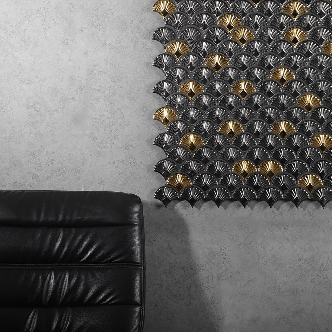 Luxury charcoal and gold fan shaped mosaic accent wall in a modern room with a leather chair.