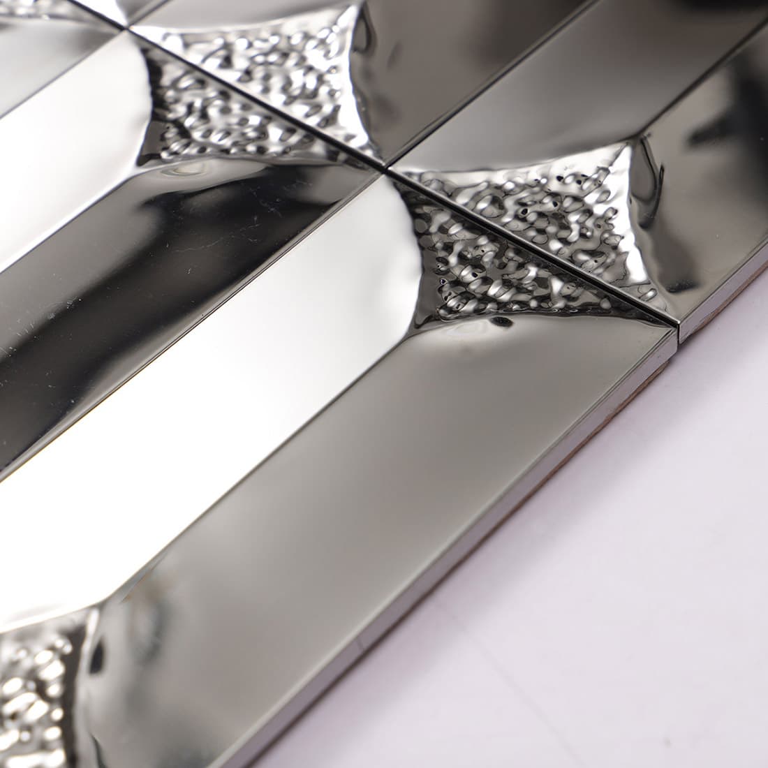 Macro shot highlighting the glossy mirror finish of silver 3D metal tiles.
