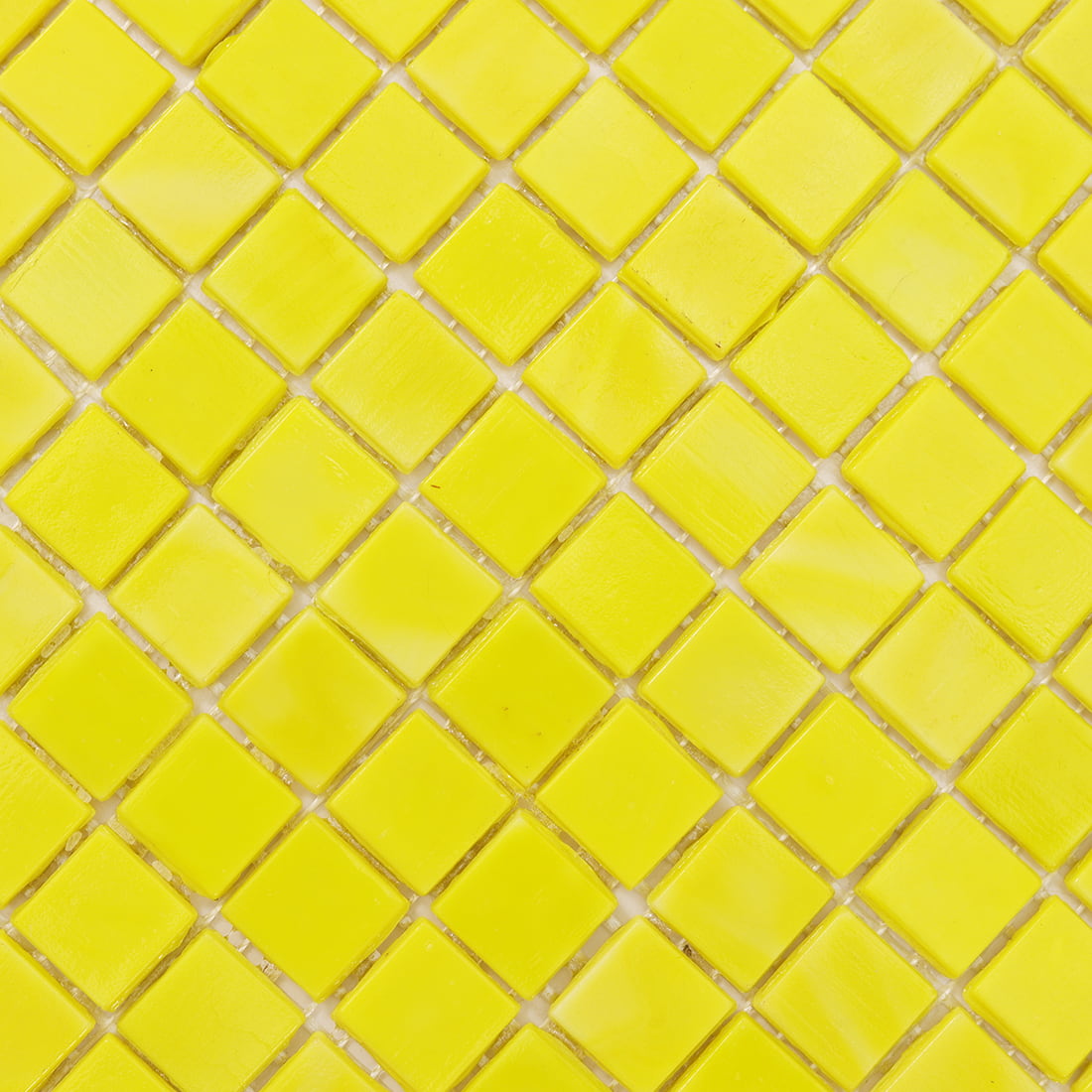 Macro shot of lemon yellow square glass tiles showing glossy surface and mesh gaps.
