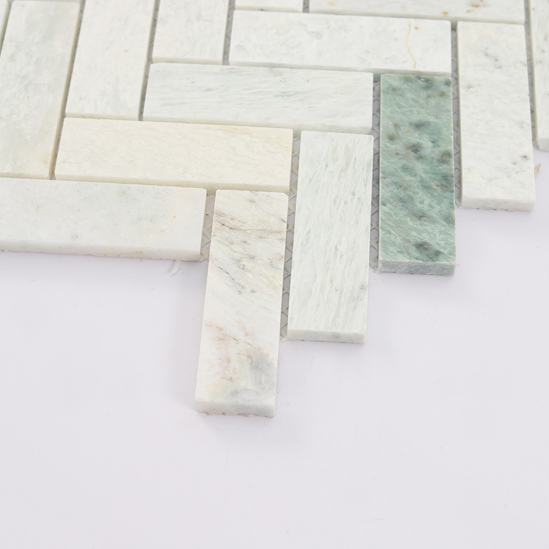 Close-up of the bottom chips of marble herringbone mosaic.
