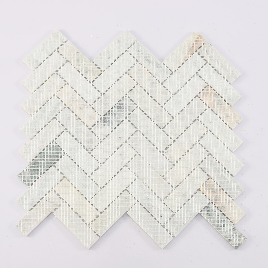 Mesh backing on the reverse side of marble herringbone mosaic.